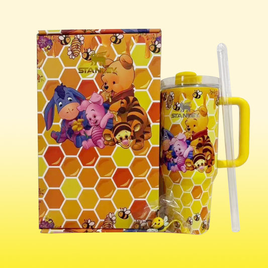 Stanley 40oz insulated tumbler featuring Winnie the Pooh and friends, honeycomb pattern background, includes matching straw and yellow handle