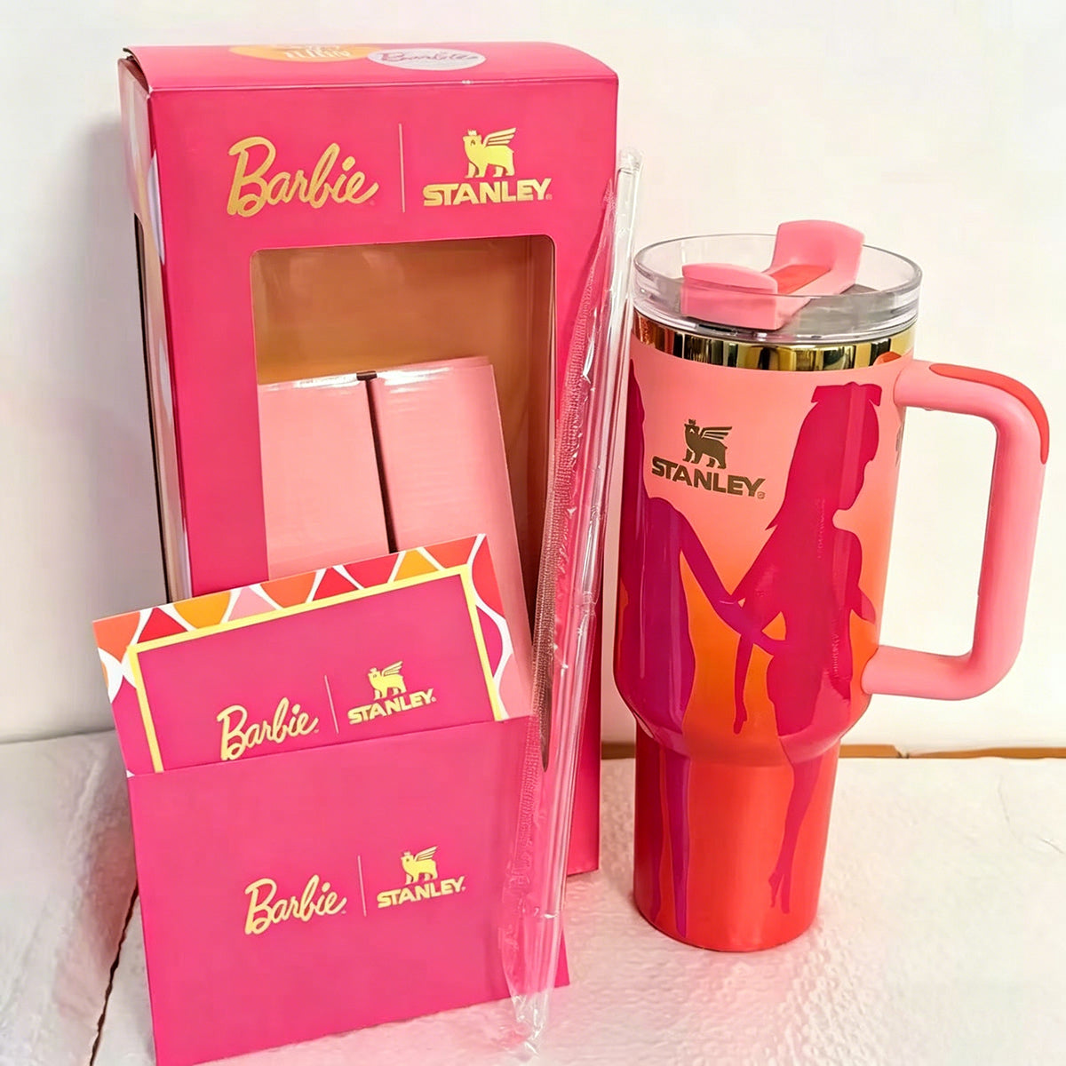 Stanley 40oz insulated tumbler featuring Barbie silhouette design on red background, matching gift box and pink handle