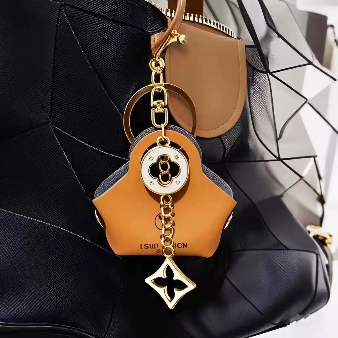 Brown leather keychain with gold chain on a black textured surface
