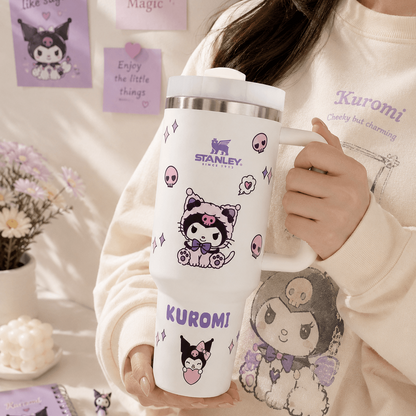 Person holding a Stanley tumbler with Kuromi character designs, surrounded by decorative elements.