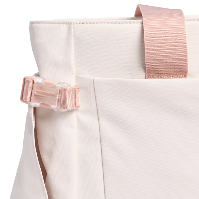Close-up of a beige bag with pink straps on a white background