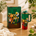 Colorful tumbler with cartoon characters on a wooden surface, next to its packaging.