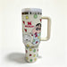Stanley 40oz insulated tumbler with Crayon Shin-chan design, playful cartoon characters, and colorful geometric shapes, white handle