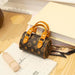 Designer handbag with brown leather handles on a wooden surface with books and a calendar.