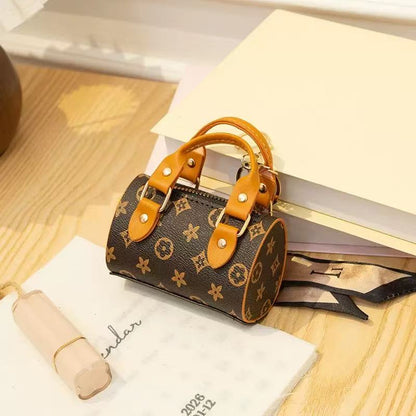 Designer handbag with brown leather handles on a wooden surface with books and a calendar.