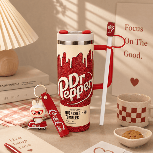 Dr Pepper tumbler with red and white design on a table with books and a lamp in the background.
