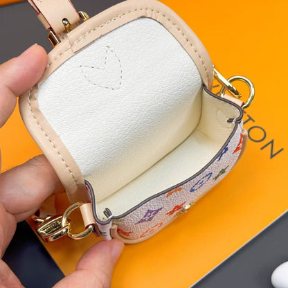 Elegant mini handbag charm keychain featuring a luxury-inspired monogram pattern, gold-tone hardware, top handle, and stylish accessory design.
