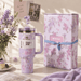 Floral-themed Stanley tumbler with matching gift box on a decorative surface.