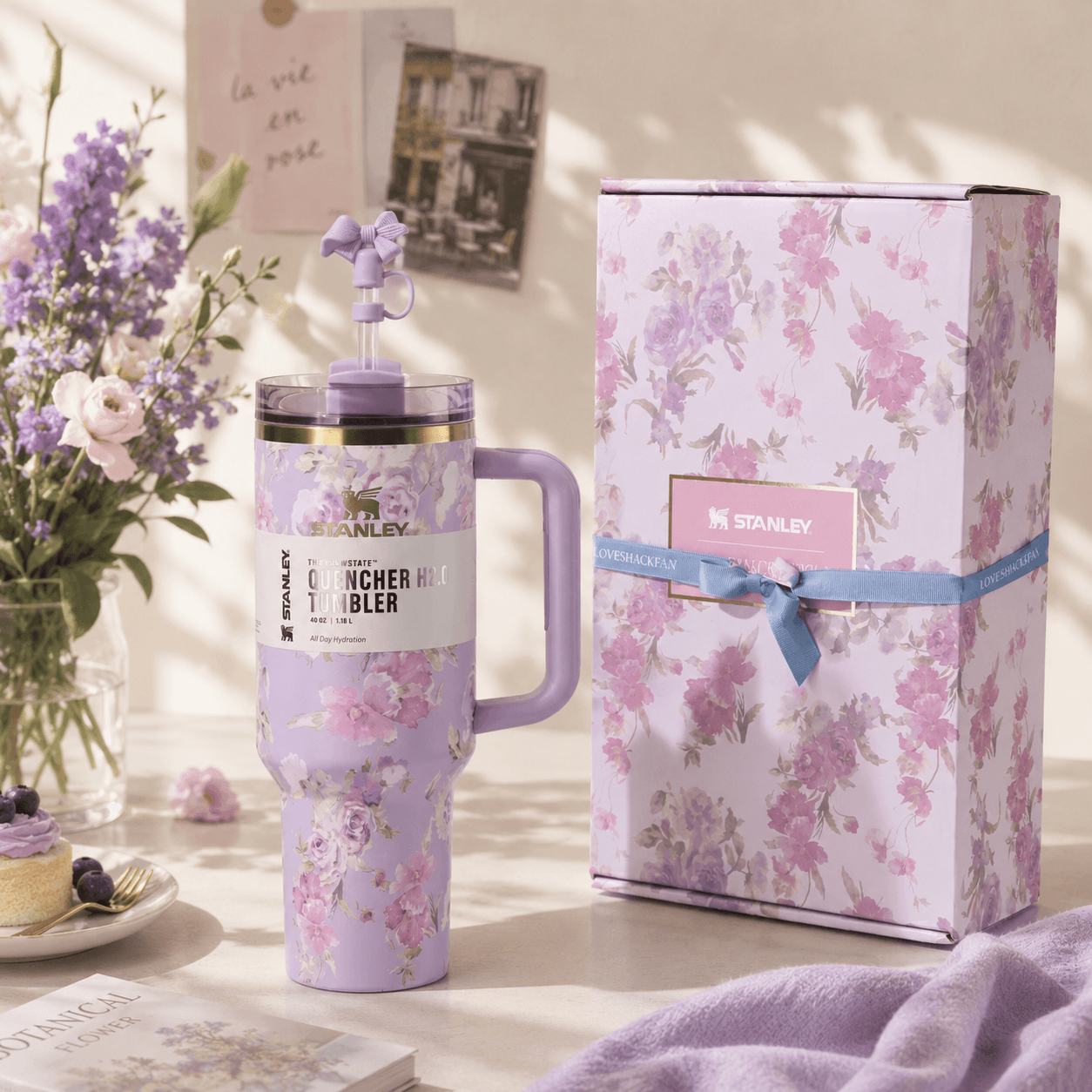 Floral-themed Stanley tumbler with matching gift box on a decorative surface.