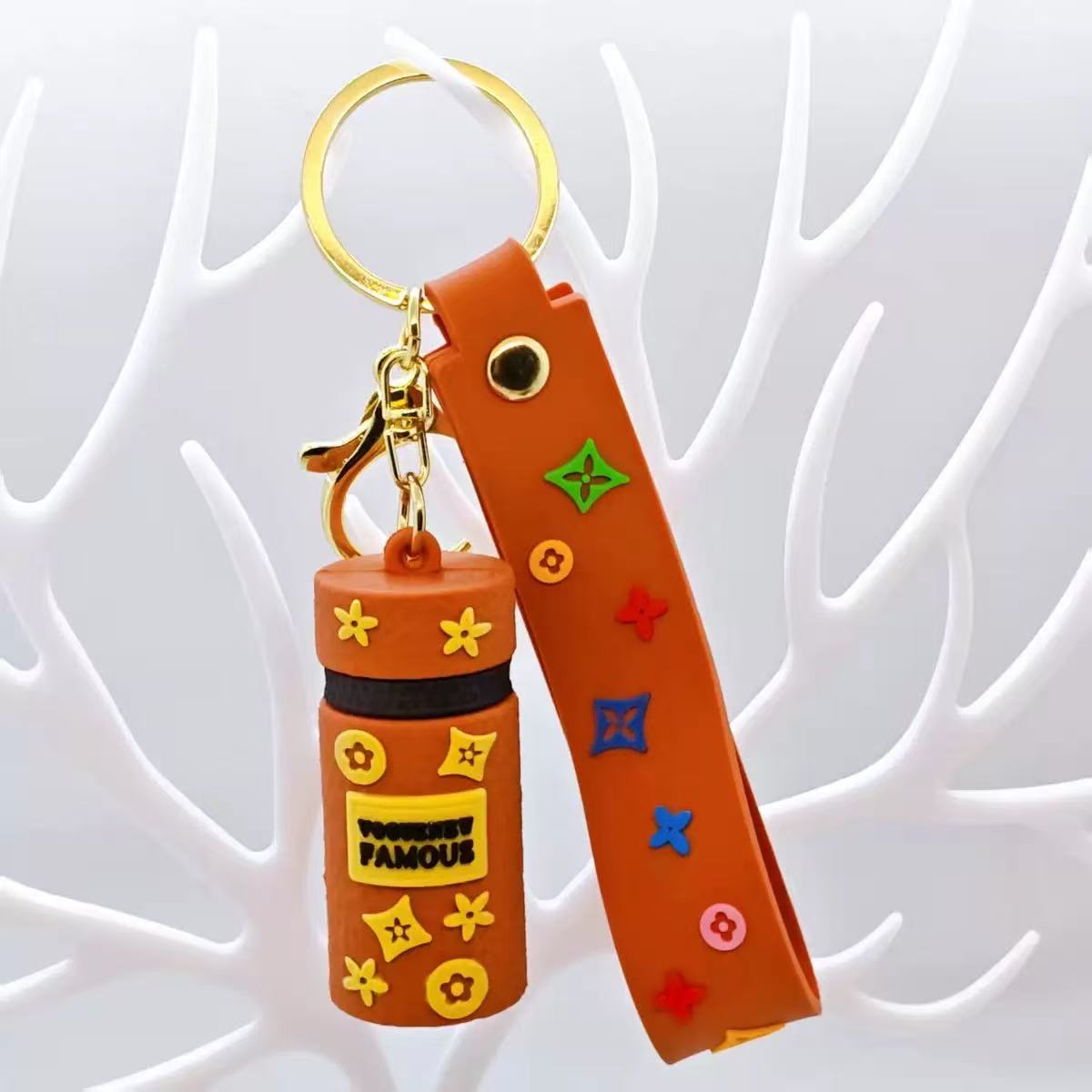 Keychain with orange bottle and strap on a white background