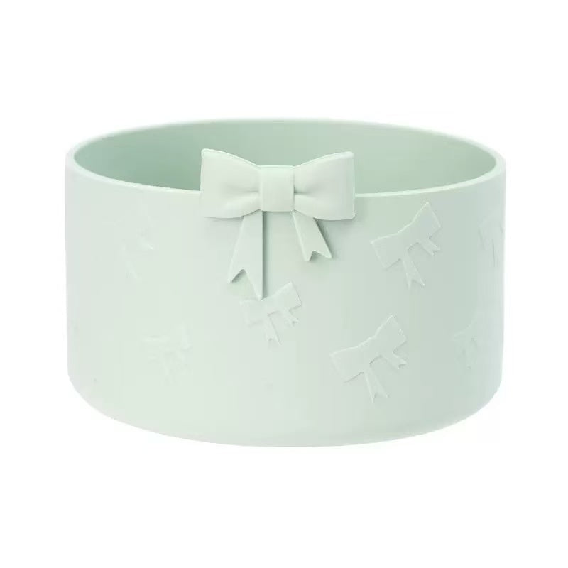 Light green pet bowl with a bow on a white background
