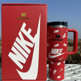 Stanley 40oz insulated tumbler with Nike logo design, red body and black handle, matching Nike-themed gift box