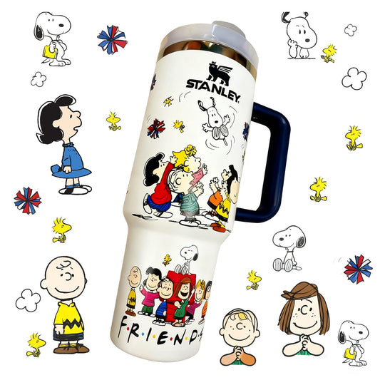 Stanley 40oz insulated tumbler featuring Peanuts Friends artwork with Snoopy, Charlie Brown and colorful comic-style illustrations, blue ergonomic handle