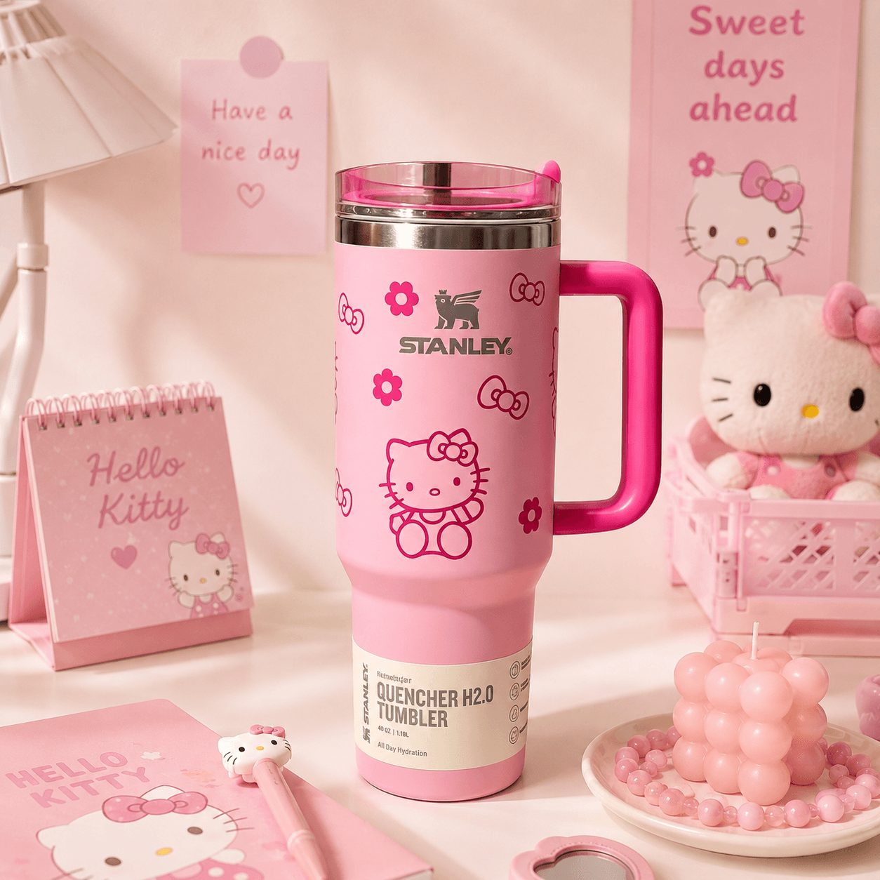 Pink Stanley tumbler with Hello Kitty design surrounded by other pink Hello Kitty products on a light background.