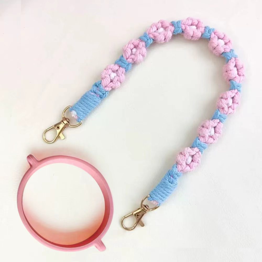 Pink and blue braided lanyard with a pink circular object on a white background
