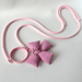 Pink dog leash with a large bow on a light gray background