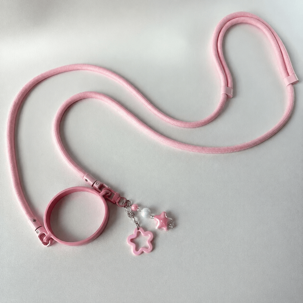 Pink pet leash with star-shaped charm on a light gray background