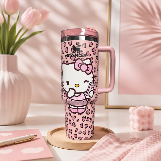 Pink travel mug with Hello Kitty design on a desk with flowers and stationery.