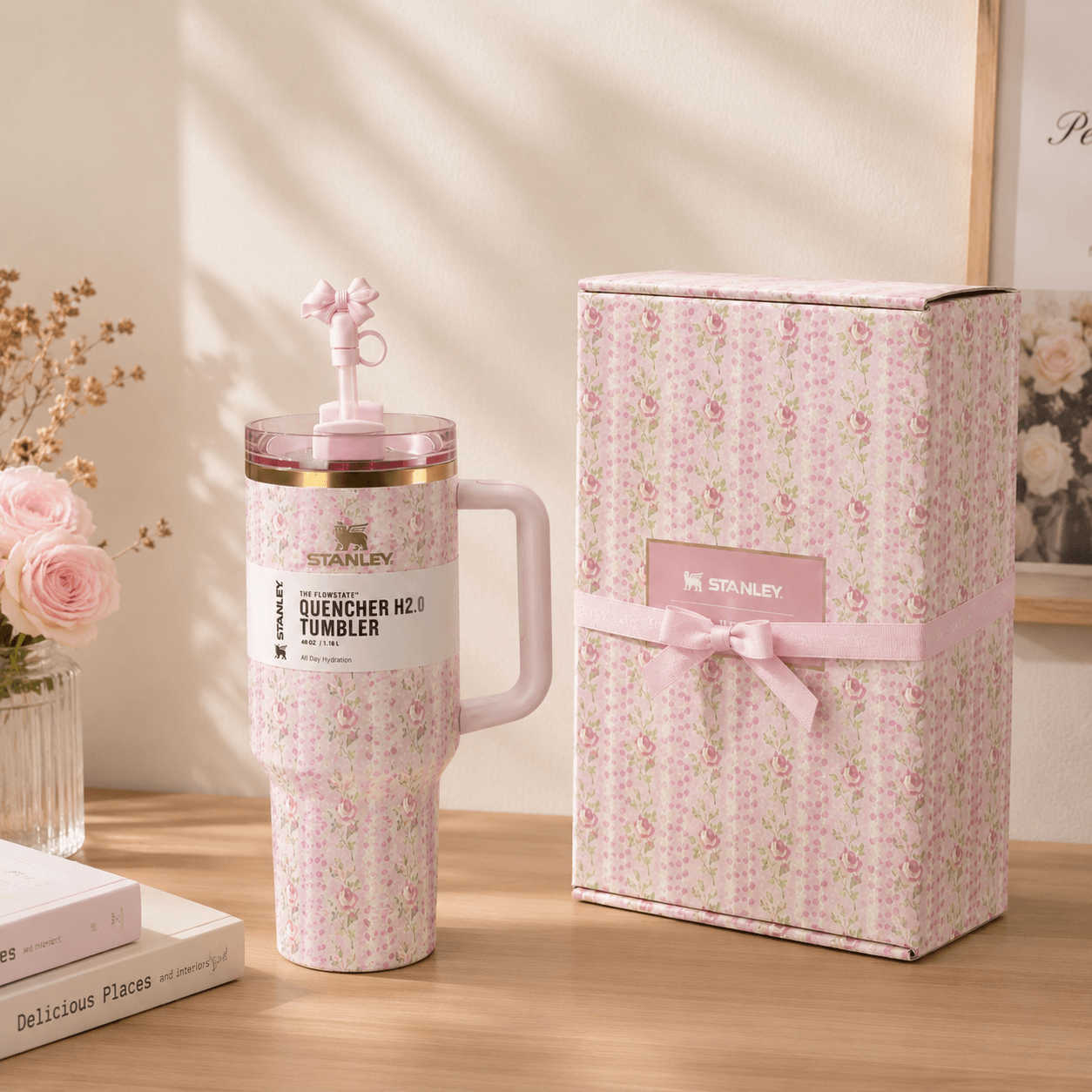 Pink tumbler with floral pattern and matching gift box on a wooden surface.