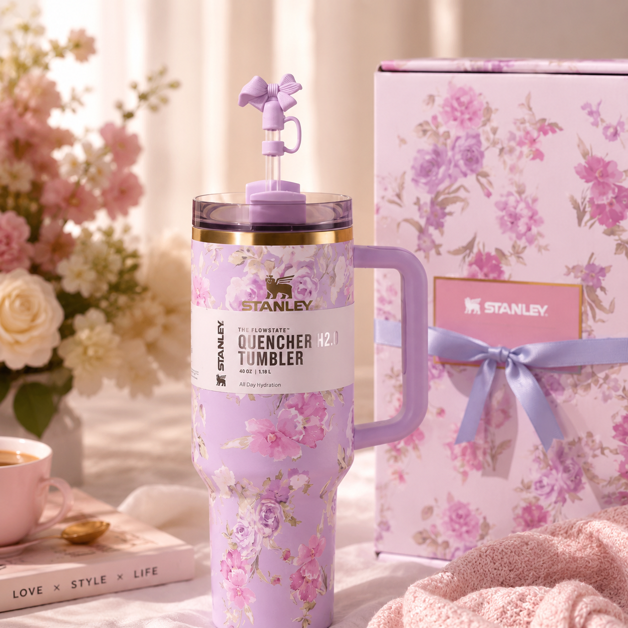 Floral-patterned Stanley tumbler with matching gift box on a decorative surface.