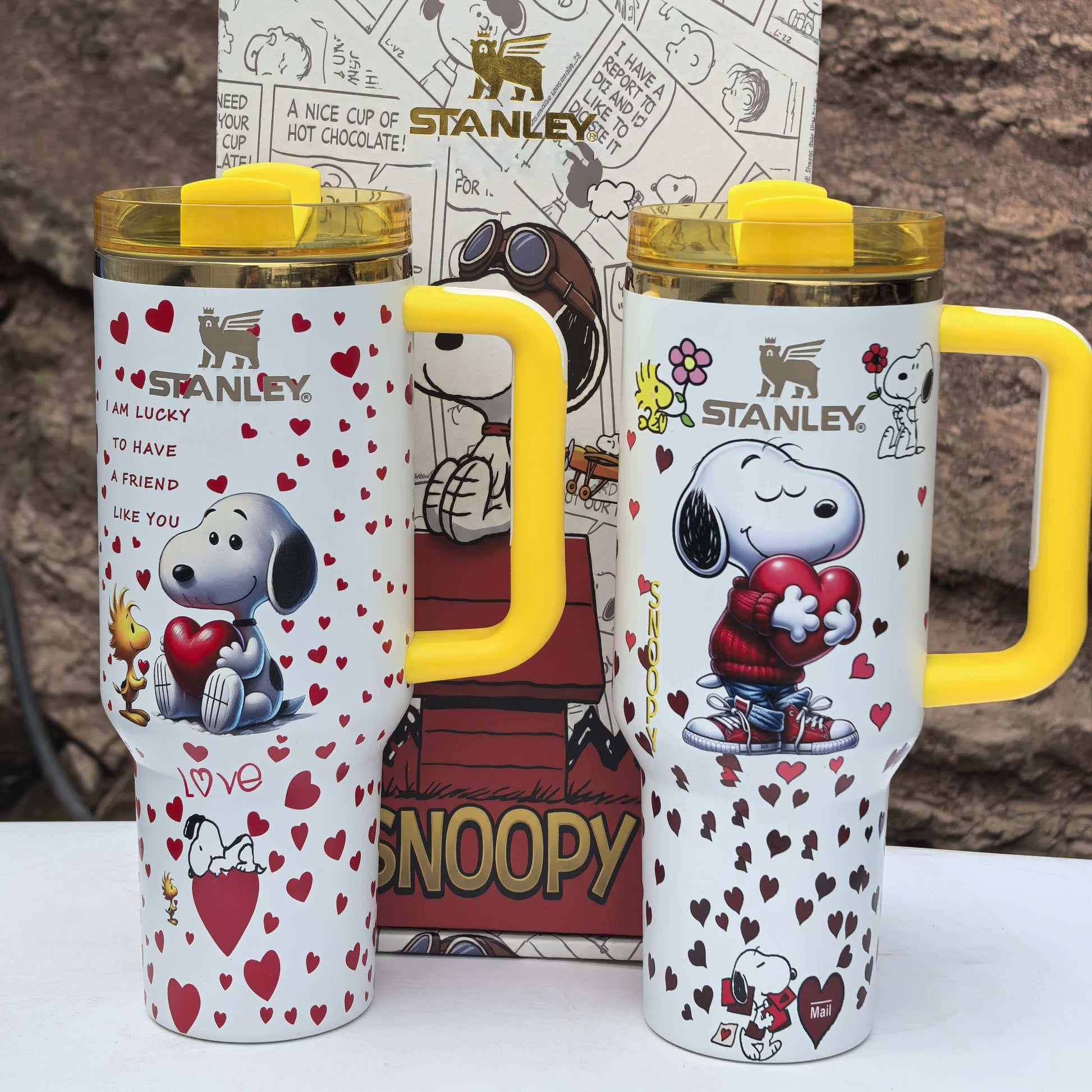 Snoopy Stanley 40oz insulated tumbler set with yellow handle and lid, holding hearts, includes matching Peanuts gift box