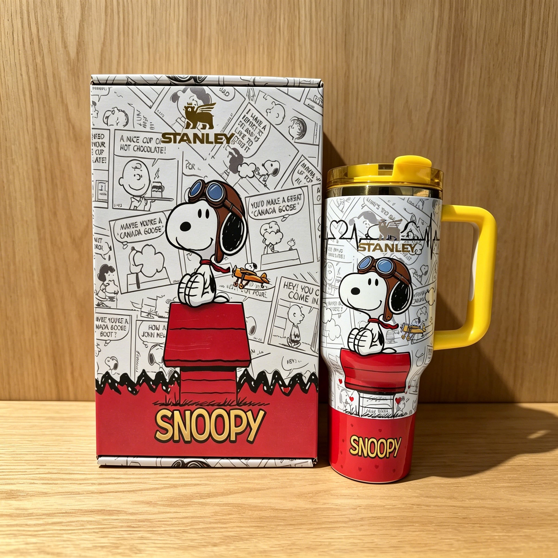 Stanley 40oz insulated tumbler with Snoopy comic strip design, red base and yellow handle, includes matching Snoopy gift box