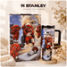 Stanley stainless steel tumbler with cartoon dog design on a decorative surface.