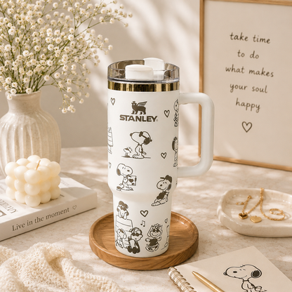 Stanley tumbler with Snoopy design on a table with decor items