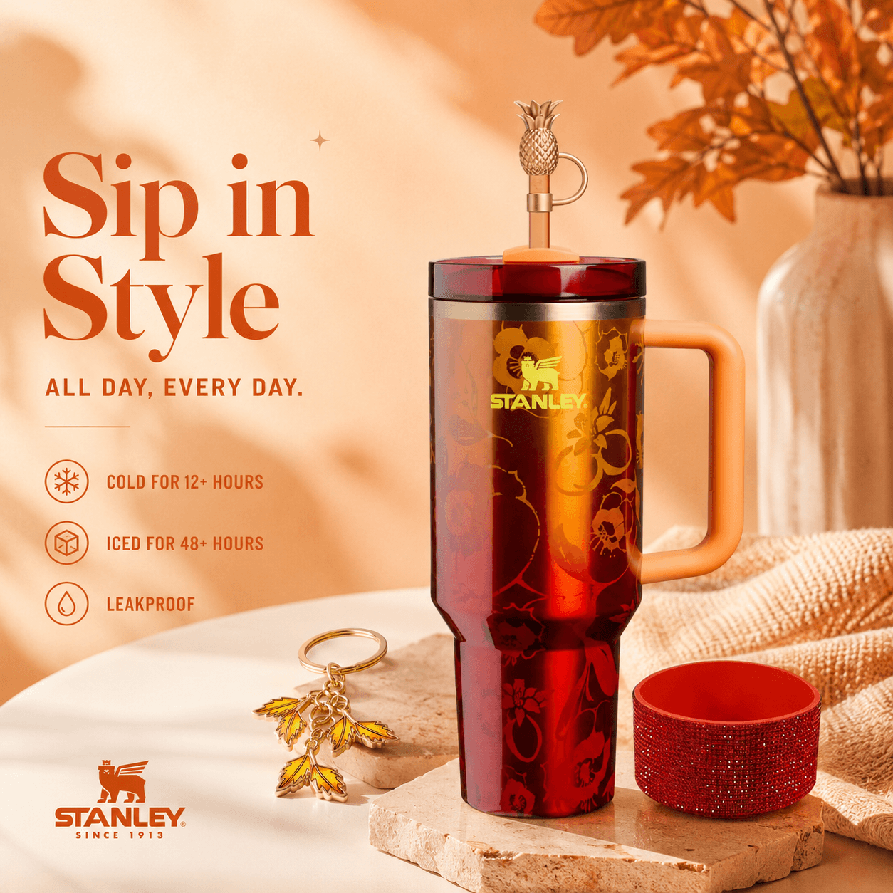 Stanley tumbler with floral design on a wooden surface with fall leaves in the background.