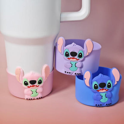 Three cartoon character cups in pink, purple, and blue on a pink background