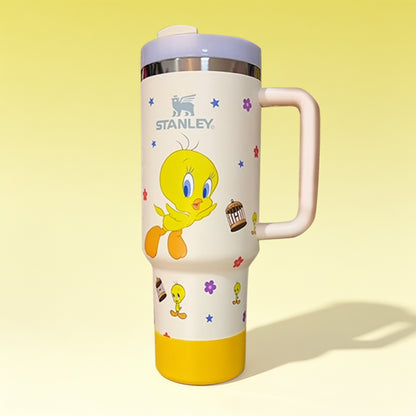 Stanley 40oz insulated tumbler featuring Tweety Bird artwork, colorful flower accents, white body with pastel pink ergonomic handle