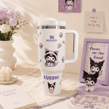 White Stanley tumbler with cartoon character design on a decorative surface with flowers and frames.