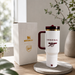 White travel mug with Arsenal logo and Stanley packaging on a wooden surface.