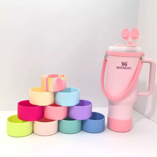 Stanley 40oz insulated tumbler with pink bow design, matching pink shoulder strap, pastel accessories and colorful cup sleeves