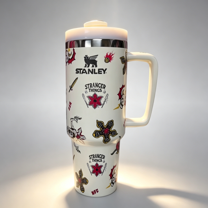 Stanley 40oz insulated tumbler with assorted tattoo-style graphics including skulls, roses, and stars, white handle