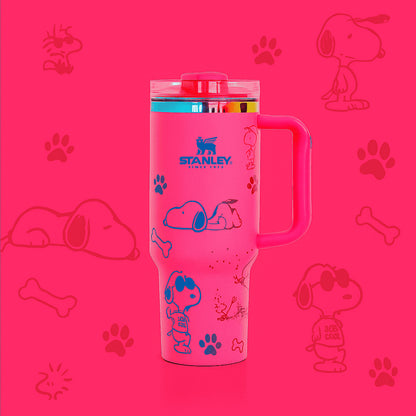 Stanley 40oz insulated tumbler featuring Snoopy illustrations, blue paw prints and bone icons, white body with white ergonomic handle