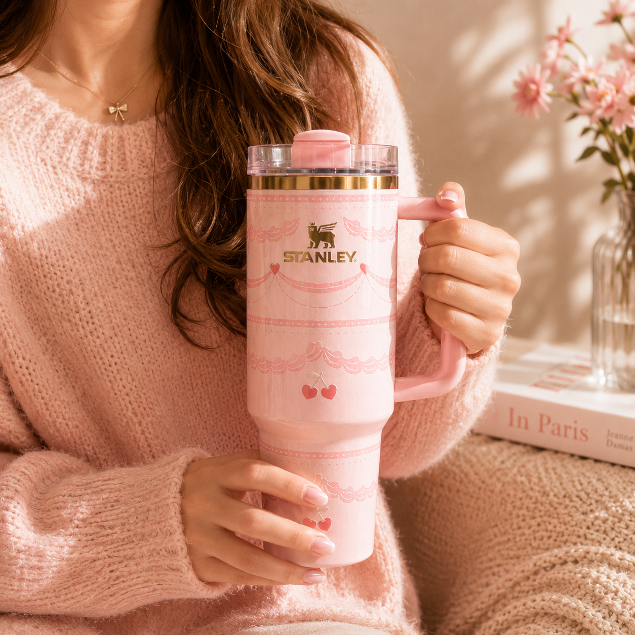 Person holding a pink Stanley tumbler with floral design