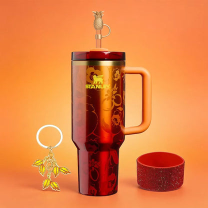 Stanley 40oz insulated tumbler with red-orange gradient finish, includes removable lid and matching keychain accessory, ergonomic handle
