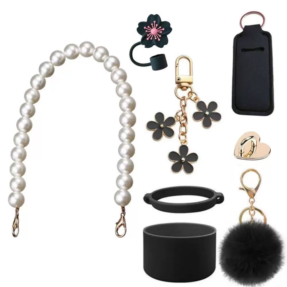 Collection of accessories including a pearl strap, flower keychains, a black cup holder, and a black pouch on a white background.