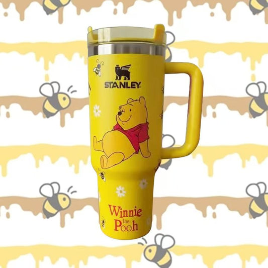 Stanley 40oz insulated tumbler featuring Winnie the Pooh artwork, yellow honey-inspired design, bee illustrations and yellow ergonomic handle